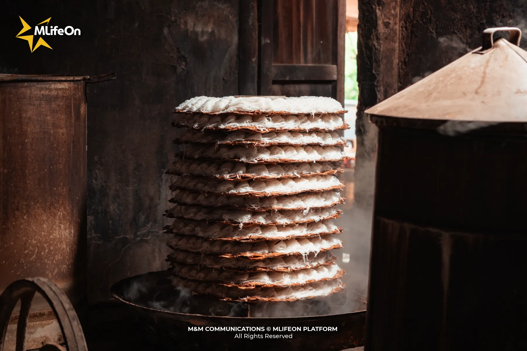 Steaming banh hoi in a kitchen filled with morning smoke.